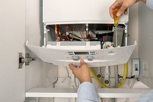 Heating technician repairing a residential boiler in Menlo Park