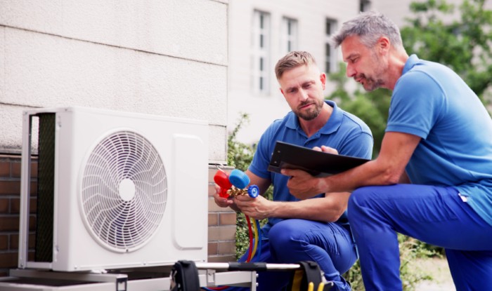 HVAC technicians installing an outdoor air conditioning unit in Menlo Park