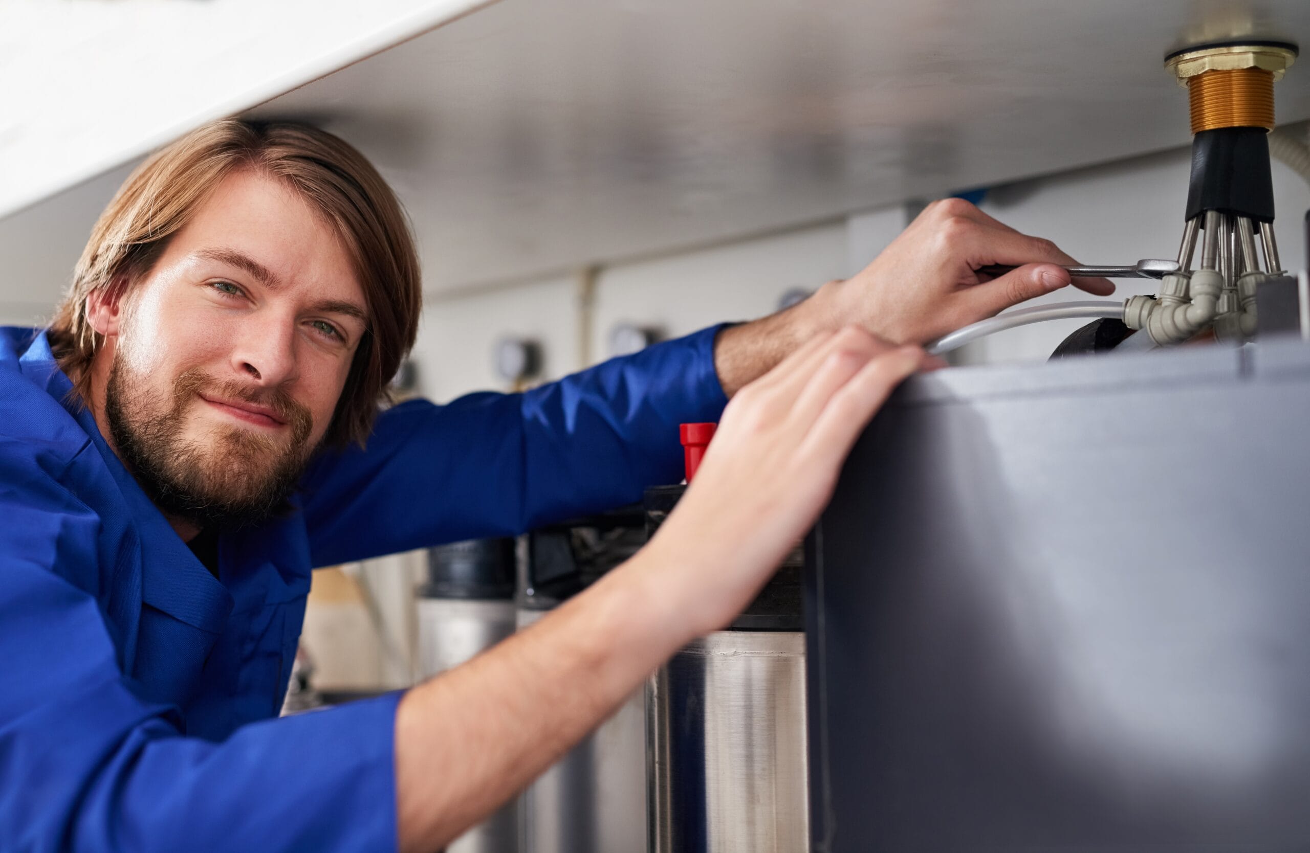 Technician servicing a residential water heater tank in Menlo Park