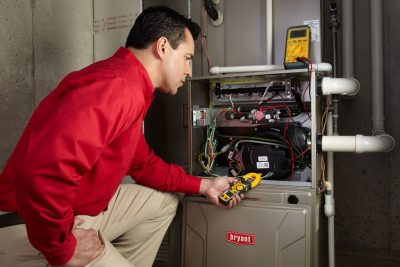 Heating technician diagnosing a furnace repair in Menlo Park