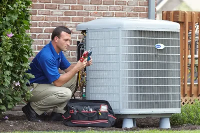 HVAC technician inspecting an outdoor AC unit in Menlo Park